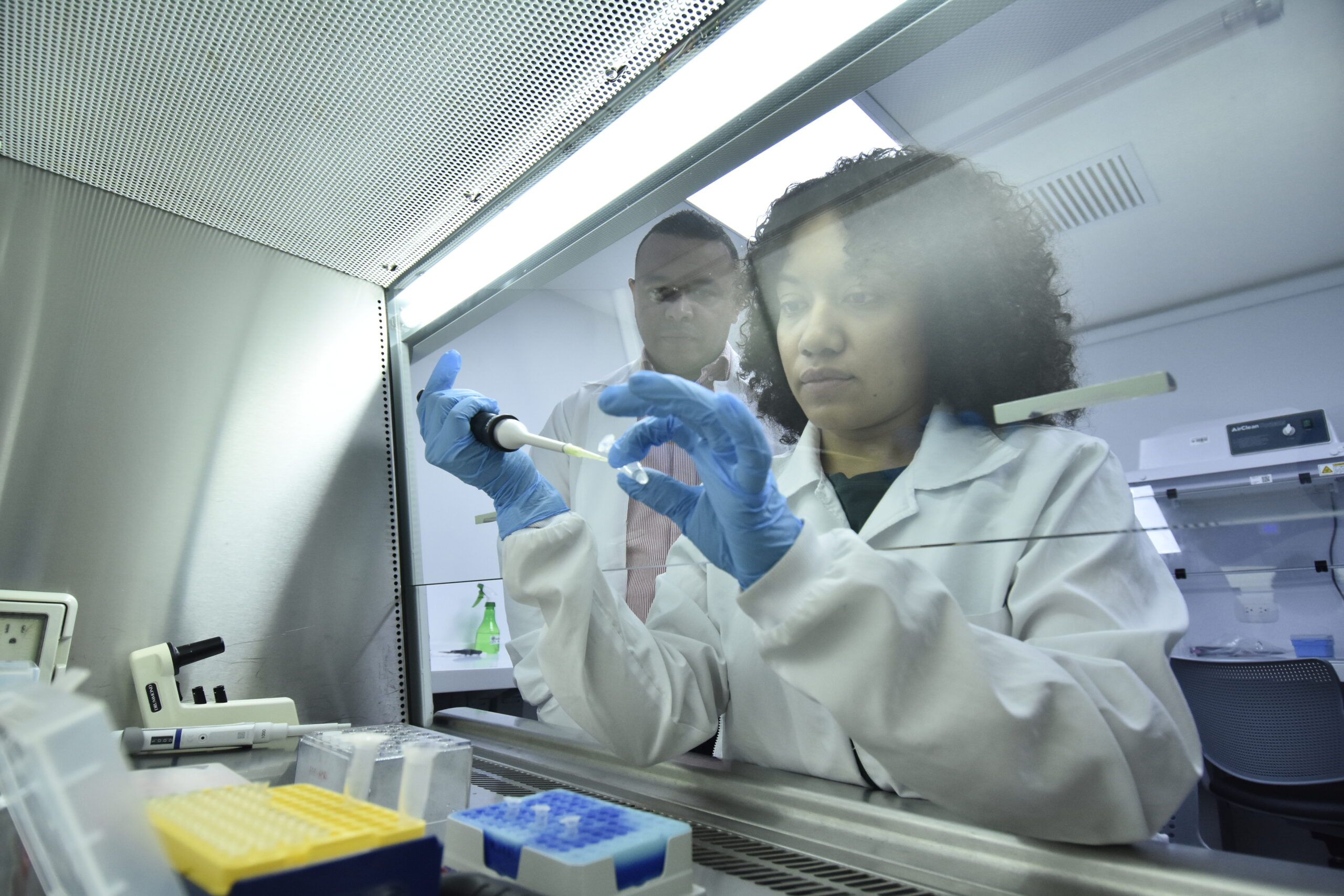 El profesor e investigador, Lisandro Pacheco, supervisa un procedimiento que hace una de sus estudiantes en el laboratorio de Genética.
